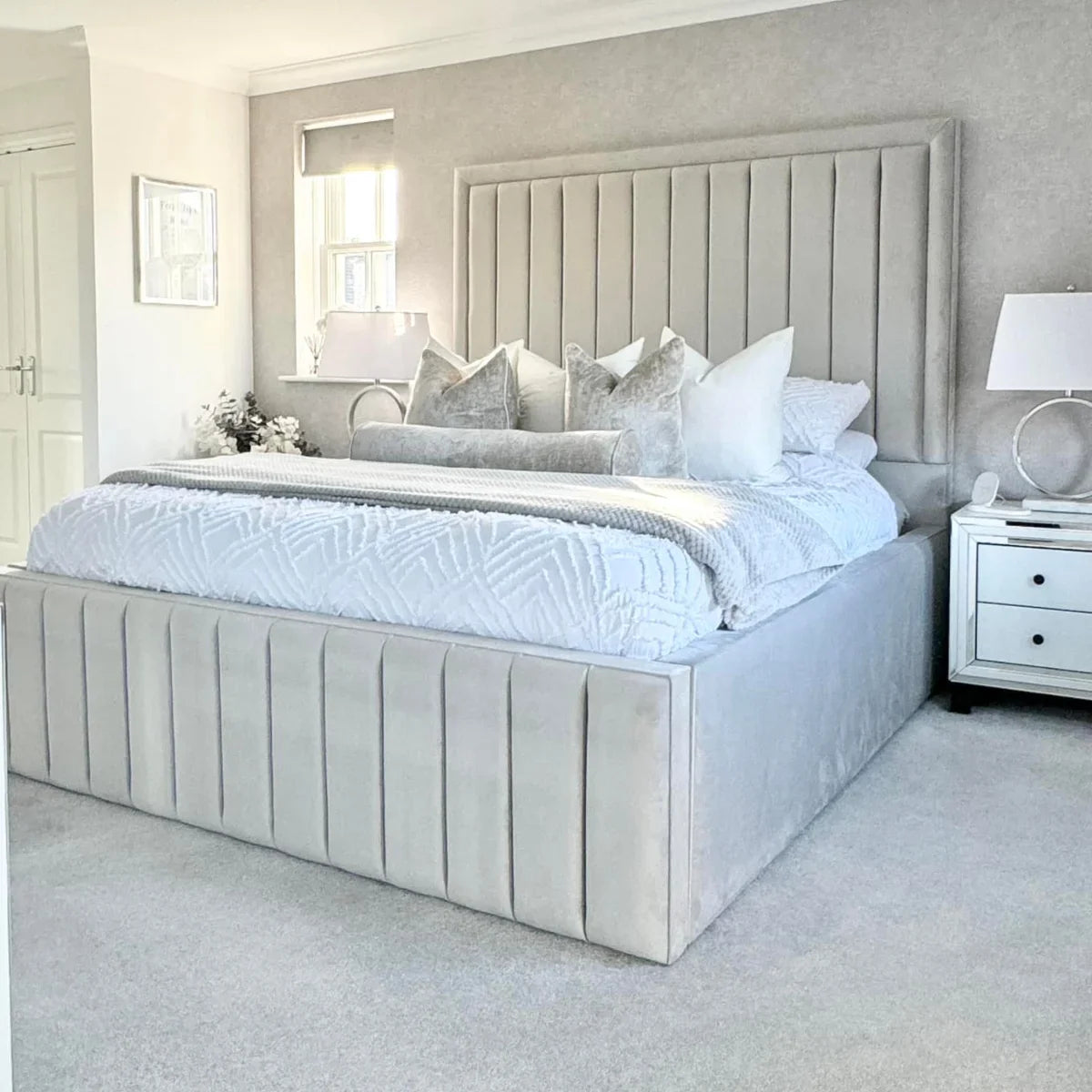 Neatly made bed with decorative pillows in a bedroom setting.