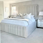 Neatly made bed with decorative pillows in a bedroom setting.